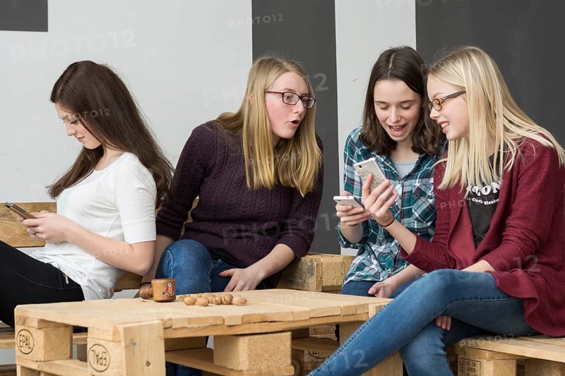 Female group of teenagers talking on mobile phones and showing different facial expressions