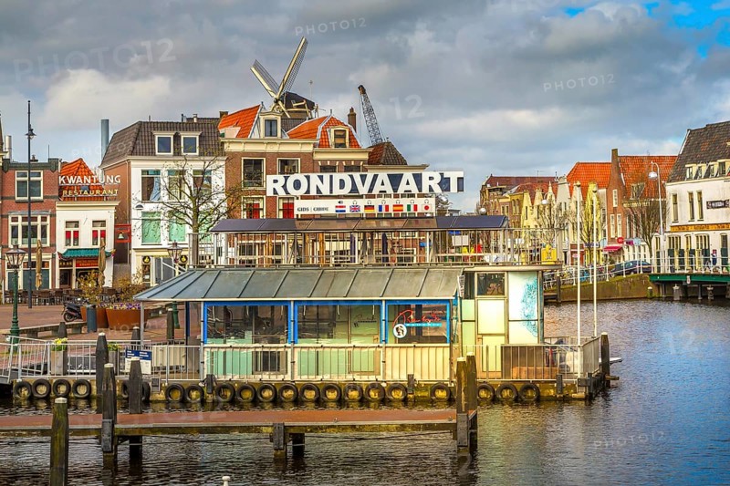 Leiden, Netherlands, April 7, 2016: Panorama with traditional dutch houses, harbour at canal and windmill in Holland