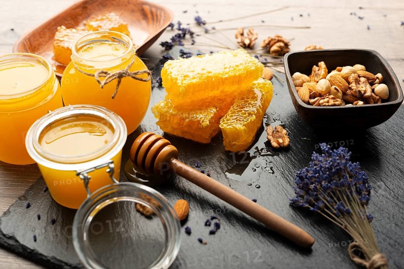 Honeycomb on slate tray with honey and nuts on kitchen table, food photography, food photography