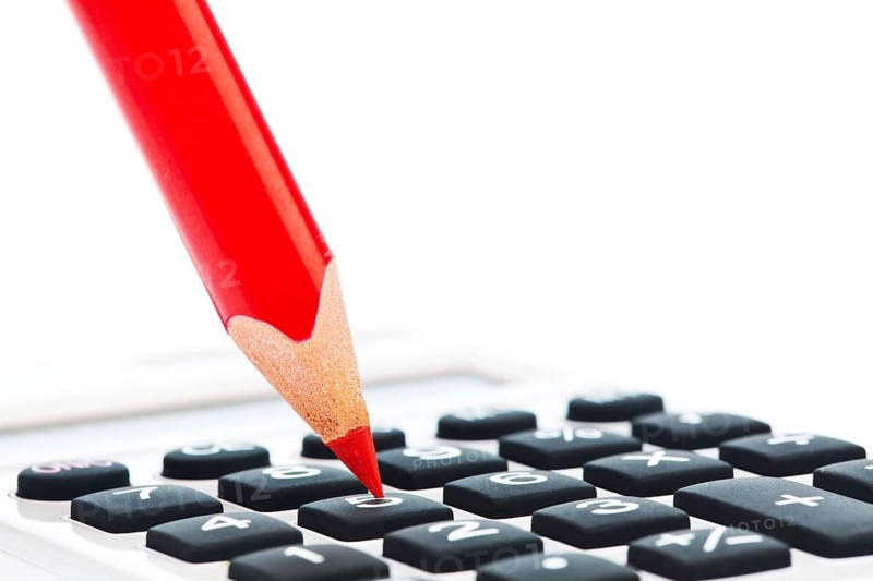 A red pencil and a calculator. Symbolic image Rationalise and save Austria