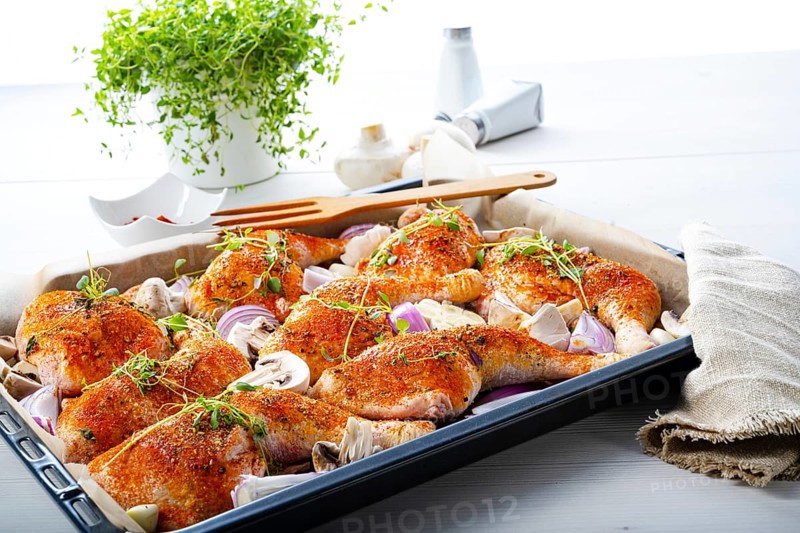 Prepared chicken legs with various vegetables and herbs