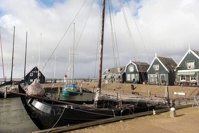 Groene houten huizen in het haventje van Marken