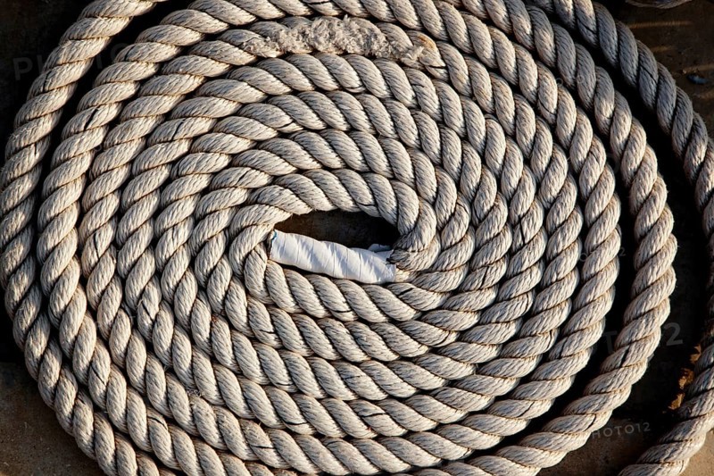 Coil of marine rope detail in marina port