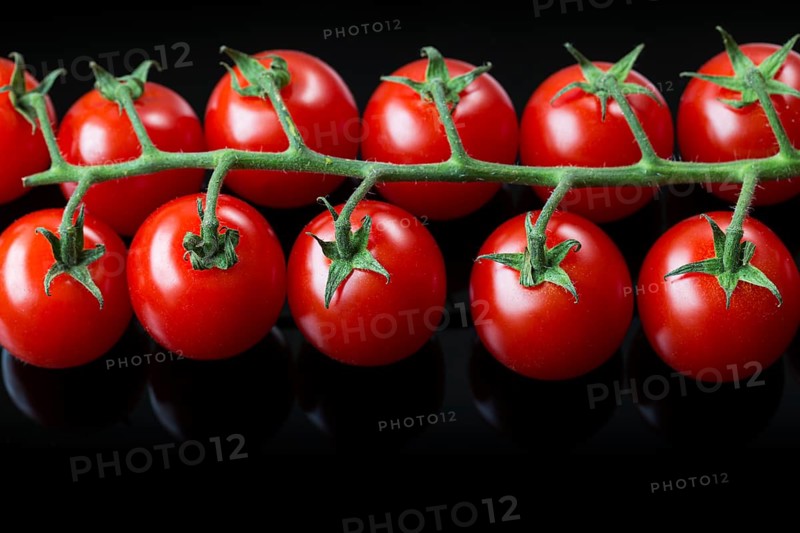 Fresh cherry tomatoes on a black background. Bunch of fresh cherry tomato on a black background