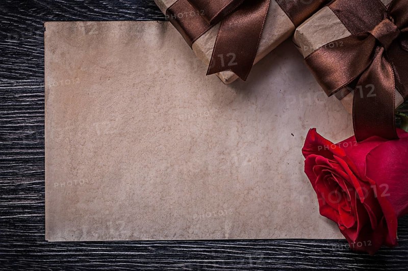 Vintage paper red natural rose wrapped giftboxes on wooden board