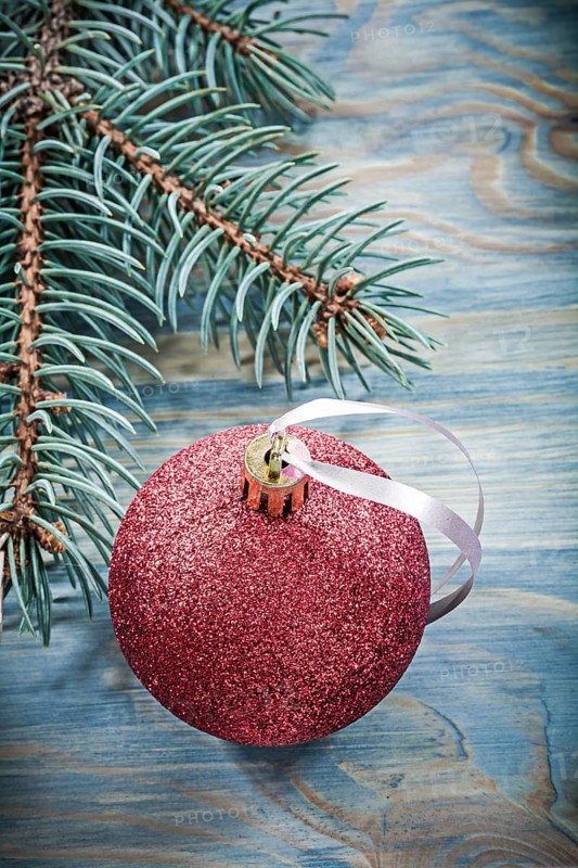 Pine branch red bauble on wooden board holidays concept