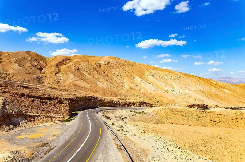 Desert on the shores of the Dead Sea. Israel. Asphalt highway meanders among the hills. Dead Sea mud has healing properties. Drone filming