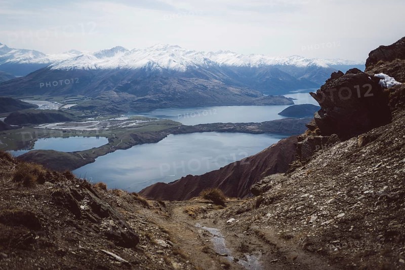 Rocky path with views of several lakes and valleys between the mountains, Roys Peak, Wanaka, New Zealand, Oceania