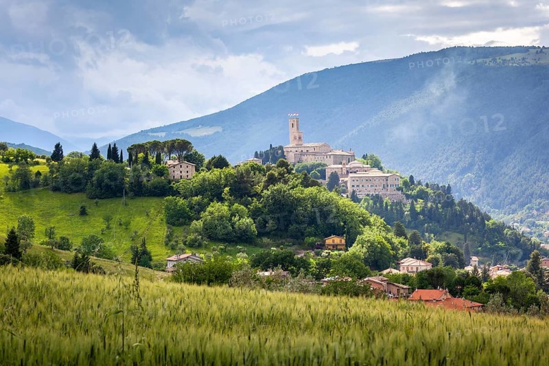 An image of Camerino in Italy Marche over colourful fields