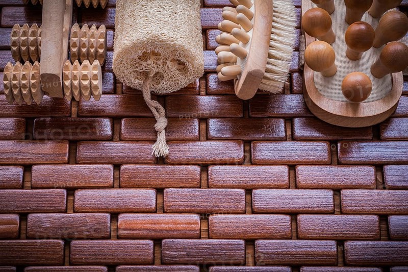 Wood scrubbing brush massagers and loofah on textured wooden place mat healthcare concept