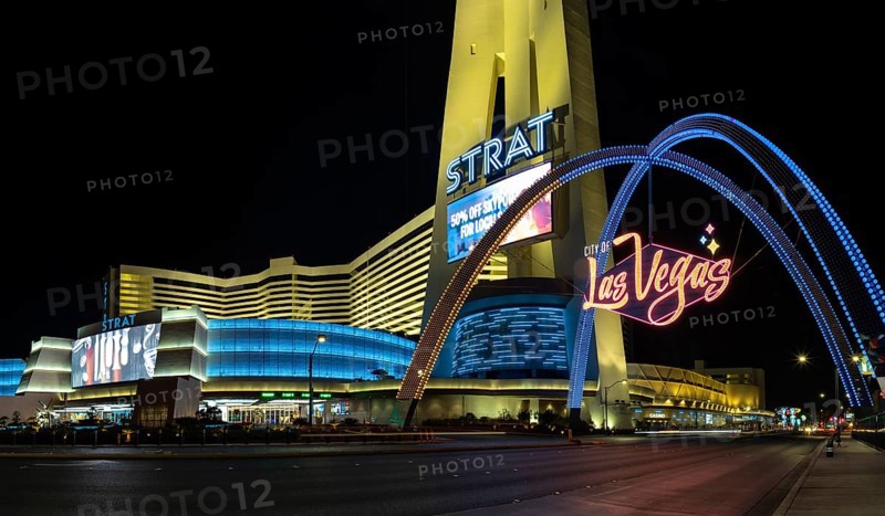 A picture of the STRAT Hotel, Casino and SkyPod and Las Vegas Boulevard Gateway Arches at night