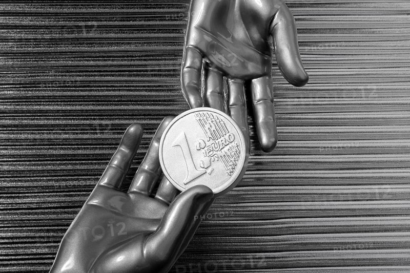 Silver euro coins in futuristic robot gray metallic hands bank metaphor