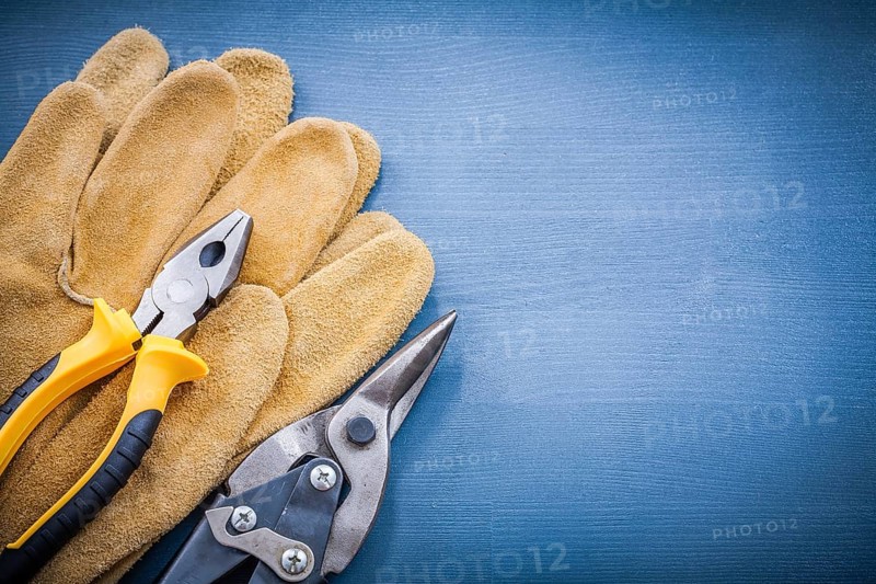 Pliers steel cutter leather protective gloves on wooden board