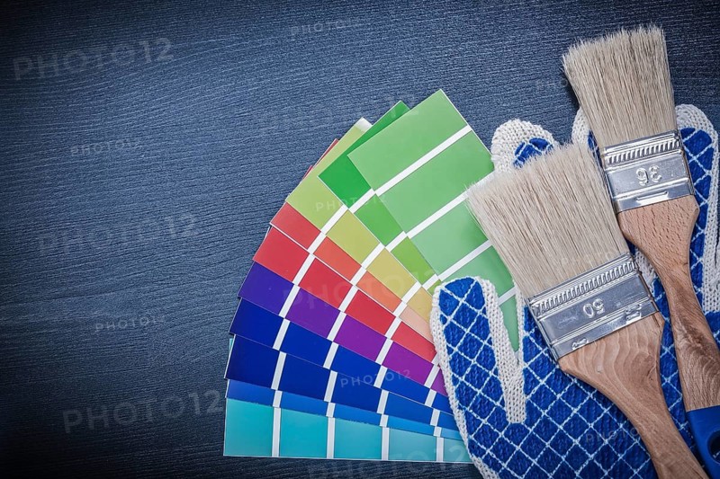 Paintbrushes pantone fan safety gloves on wooden board
