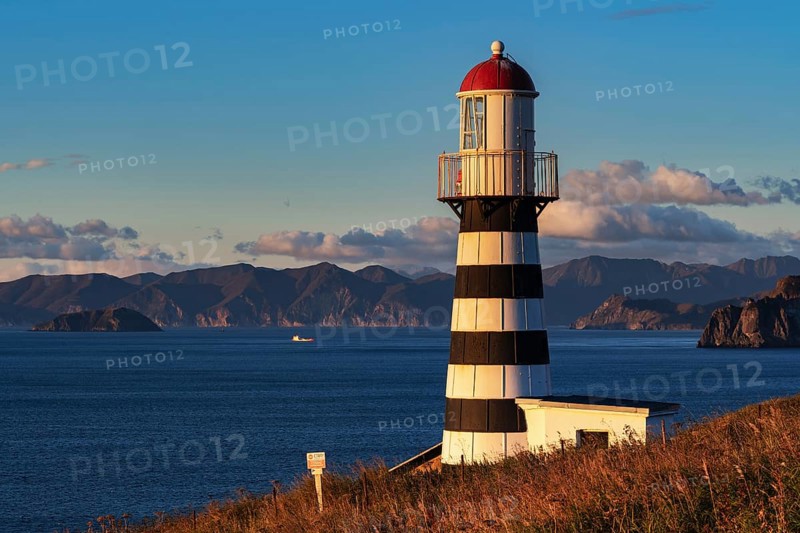 Petropavlovsky Lighthouse founded in 1850 located on Kamchatka Peninsula on shore of Avacha Gulf in Pacific Ocean, vicinity of Petropavlovsk-Kamchatsky City. View of lighthouse in morning at sunrise