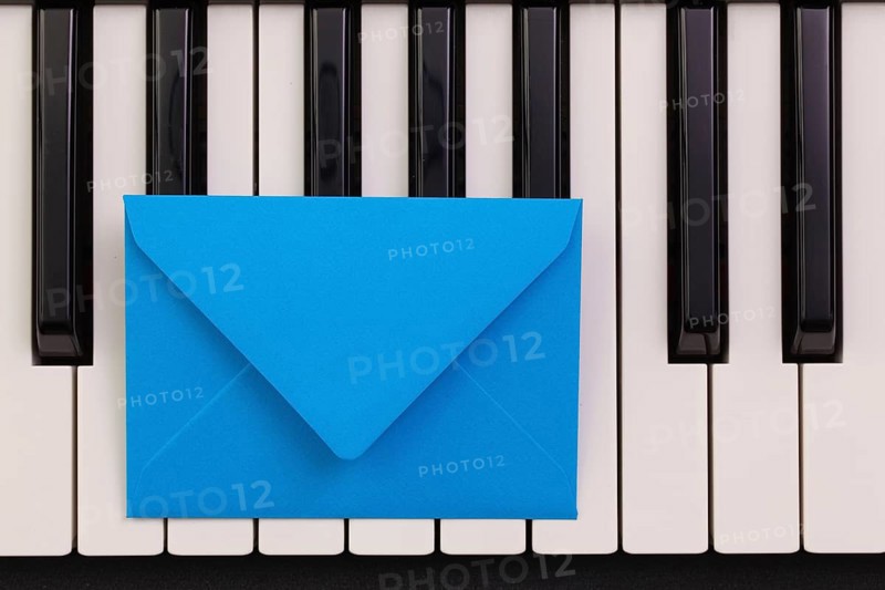 Funny arrangement envelope on the piano keybords - Flat lay image