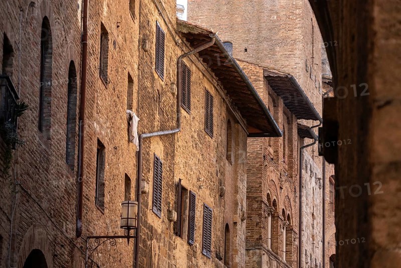 Facade of typical medieval residential houses in downtown San Gimignano, Italy, Europe