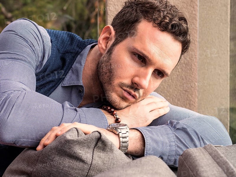 Handsome elegant man at home, wearing shirt and vest, looking away to a side
