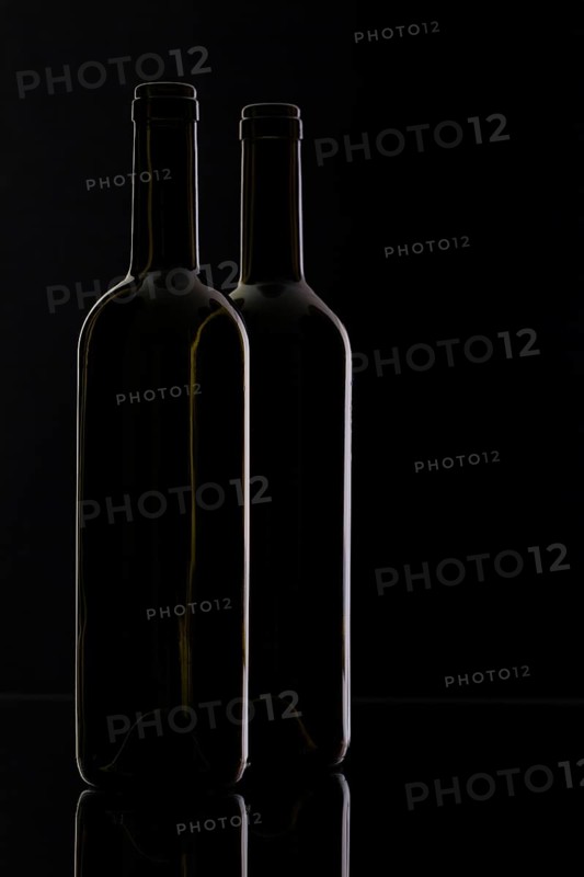 Two different bottles of wine on the black background