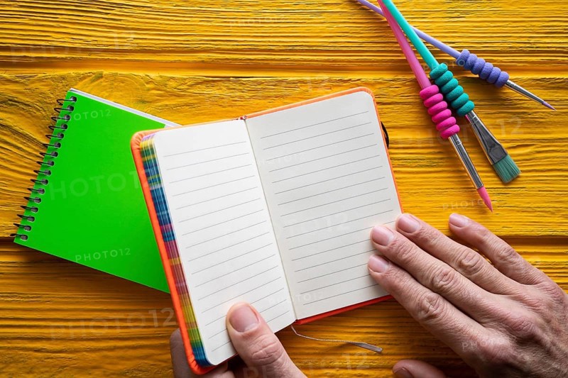 Back to school supplies notebook an brushes vivid colorful neon teachers hand