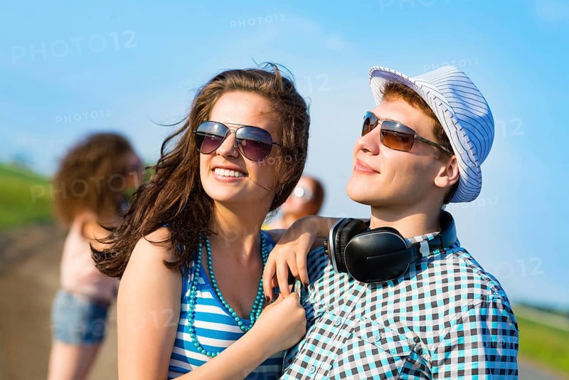 Young couple standing on the road, having fun with friends