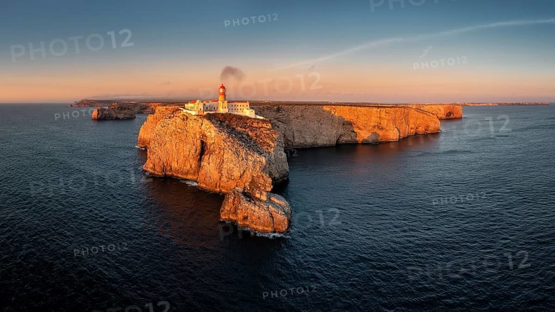 Portuguese coast with a lighthouse in the rays of the setting sun, Cabo De Sao Vincente on sunset