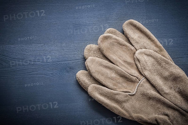 Two protective gloves on wooden board