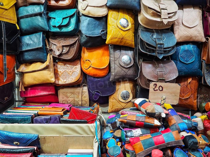Handmade colourful leather bags and purses on display at traditional souk - street market in Morocco