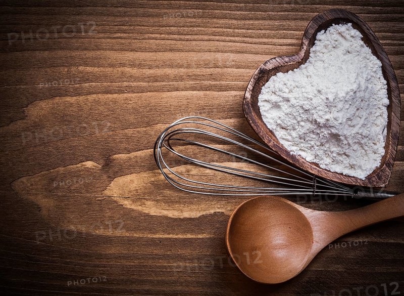 Wooden spoon heartshape bowl flower beater on wood board