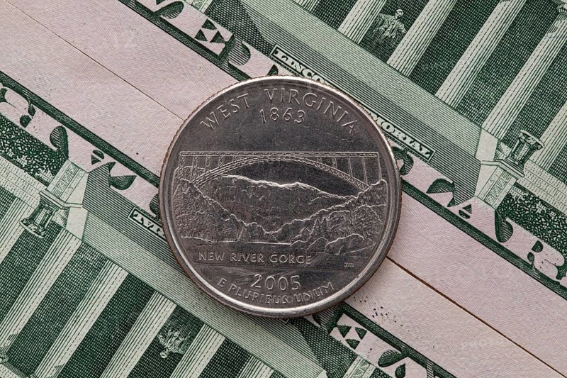 A quarter of West Virginia on US dollar bills. Symmetric composition of US dollar bills and a quarter of West Virginia