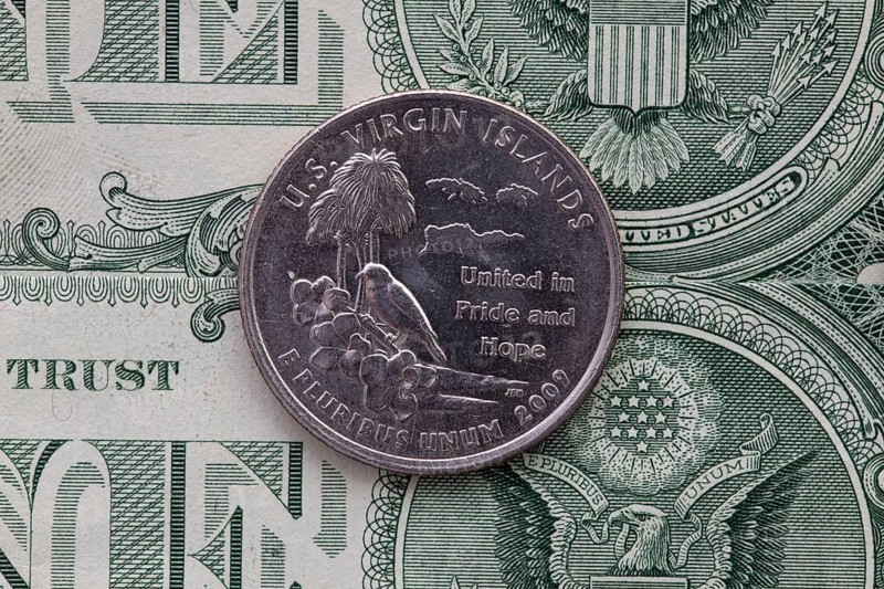 A quarter of U.S. Virgin Islands on US dollar bills. Symmetric composition of US dollar bills and a quarter of U.S. Virgin Islands