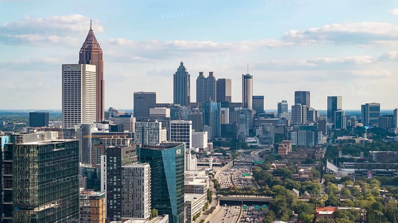 Aerial views of Atlanta showcase a vibrant cityscape with sleek skyscrapers, lush green spaces, and iconic landmarks like Mercedes-Benz Stadium. Highways, railroads, and hills weave through this bustling metropolis, Atlanta, United States of America