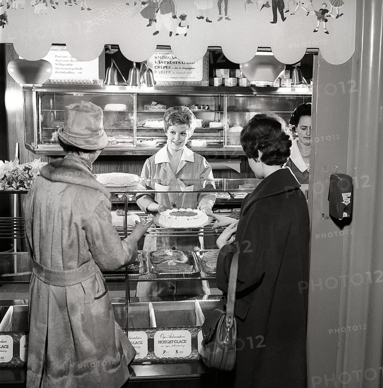 1960s coffee shop. Two women are standing in front of the counter that is full with freshly baked cakes and pastries. Sweden 1960s ref CX80-4