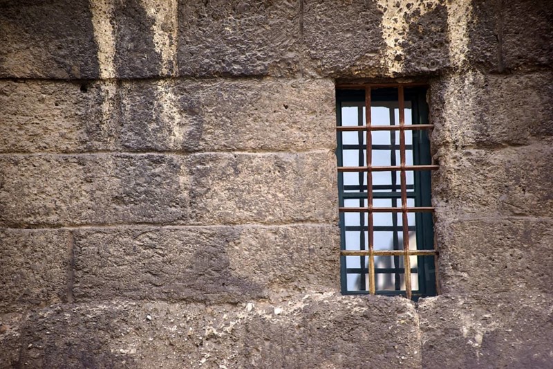 The nostalgic window of an old building with escape-proof iron bars as window grilles