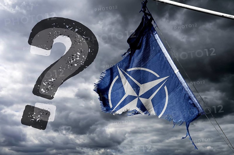 Torn NATO flag with question mark, photomontage
