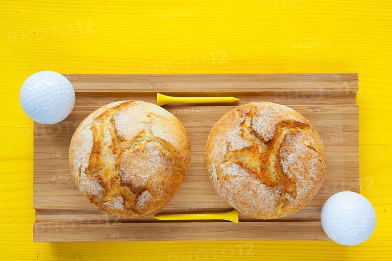 Golf breakfast - Two wheat bread and golf balls on wooden desk