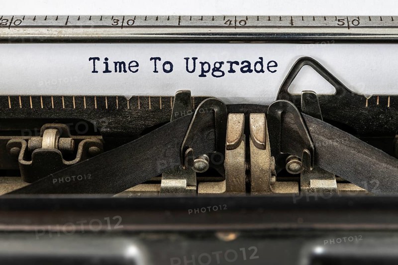 A vintage typewriter with the text time to upgrade