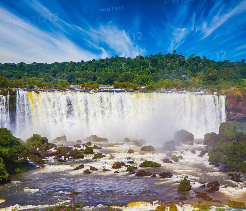 Incredible exotic waterfalls of Iguazu on the border of Brazil, Argentina and Paraguay. Concept of active and extreme tourism. Huge stones and boulders among the raging water