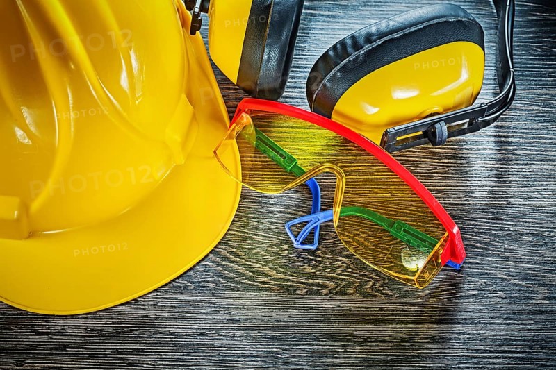 Building helmet goggles earmuffs on wooden board