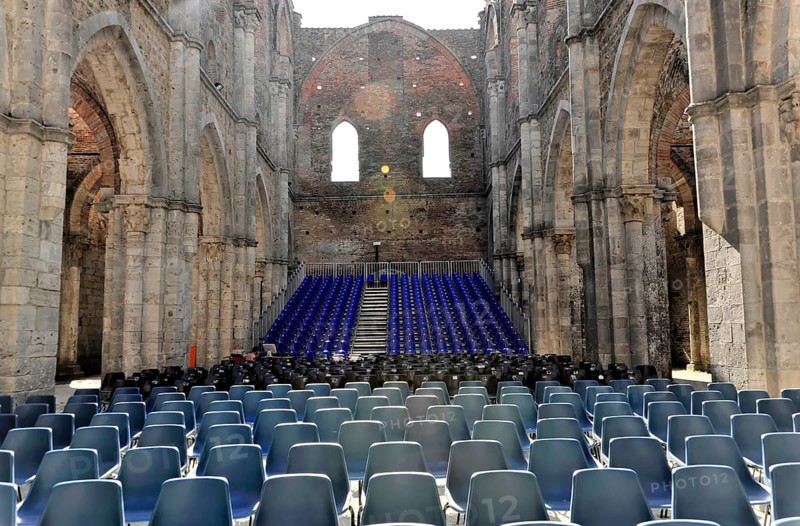 Church ruins of the Cistercian Abbey of San Galgano, Abbazia San Galgano, Gothic, Chiusdino, Tuscany, Italy, Europe, Interior view of a church ruin with many rows of chairs and light-flooded stone walls, Europe
