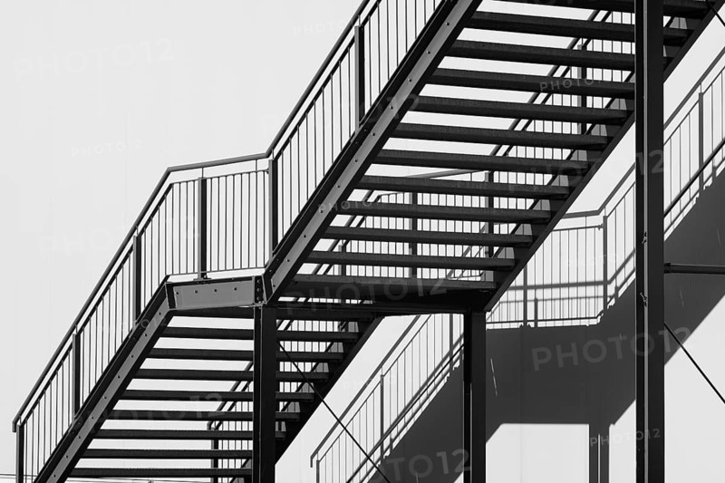 Greyscale shot outdoor stairway to the building in the sun