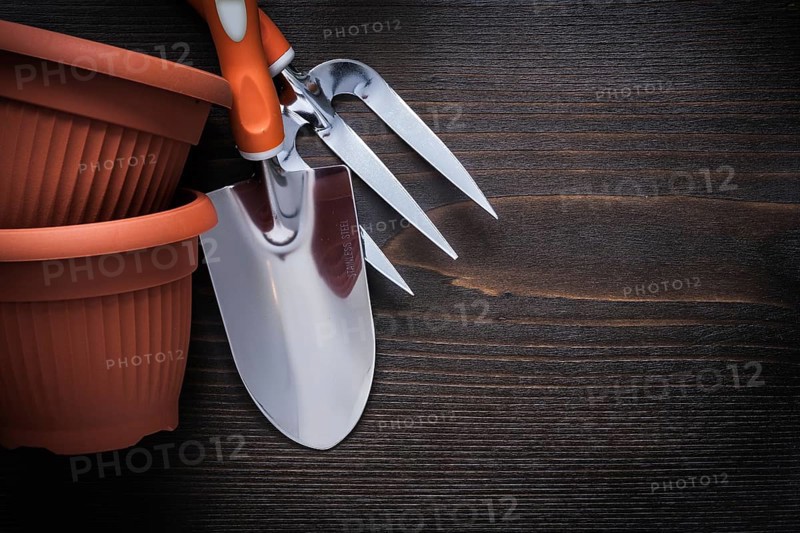Clay gardening pots trowel fork and hand spade on vintage wood board agriculture concept