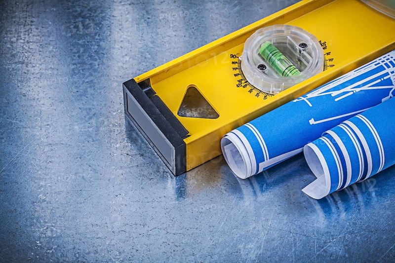 Blue engineering drawings construction level on metallic background maintenance concept