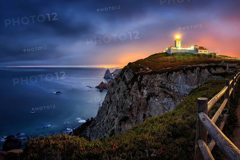 Farol do Cabo de Boca, Portuguese coast with a lit lighthouse at night