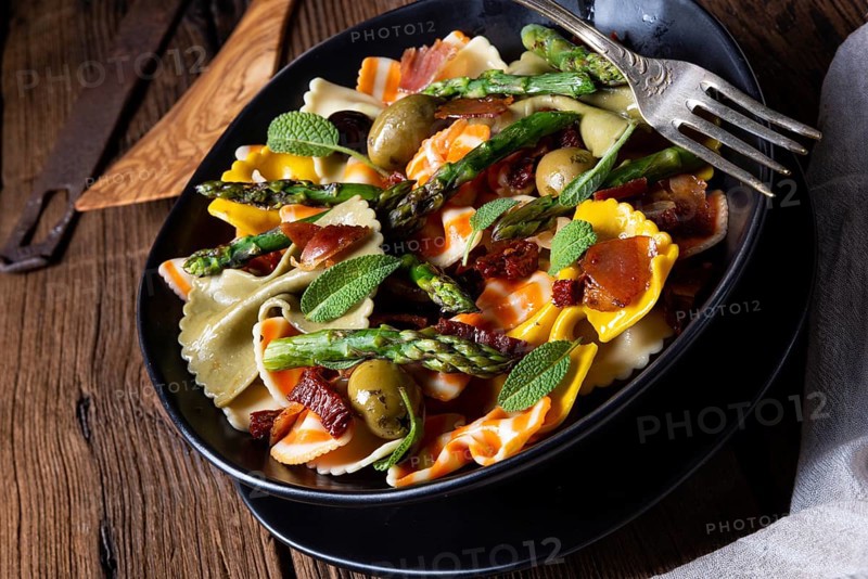 Pasta salad with green asparagus, olives and Parma ham
