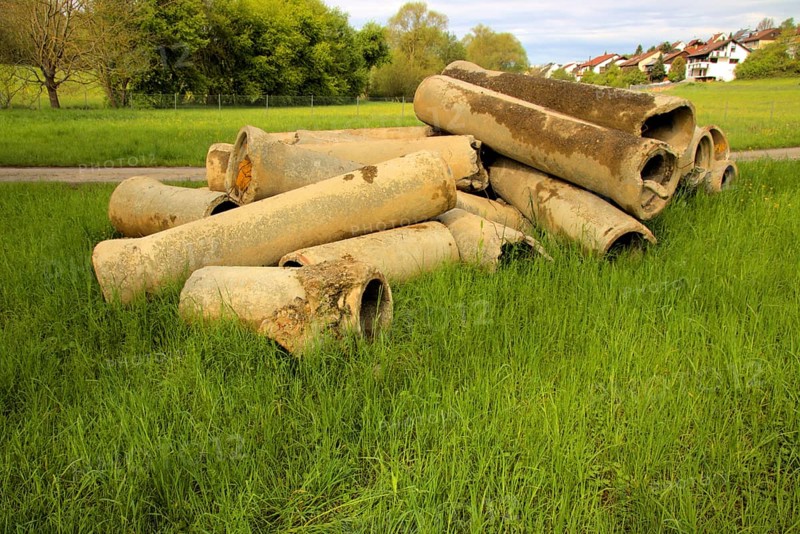 Dismantled concrete pipes in a meadow