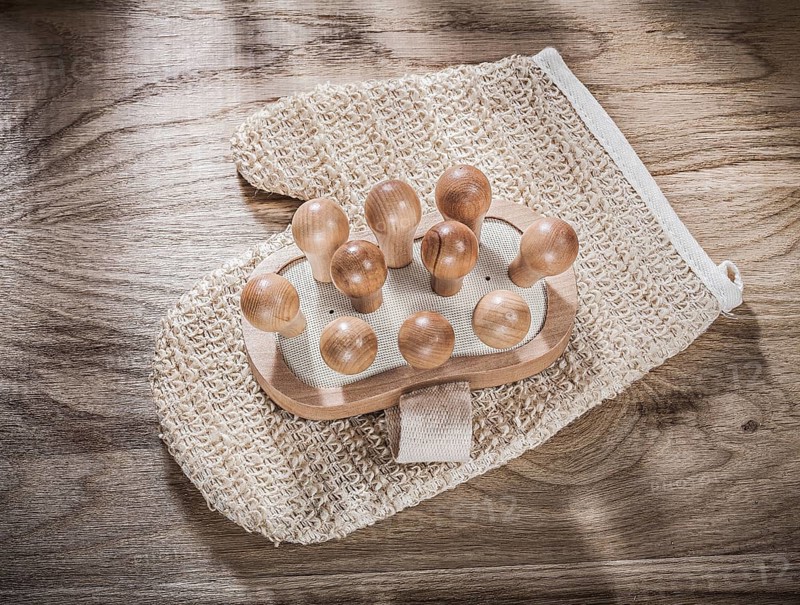 Massager body scrubber on wooden board healthcare concept