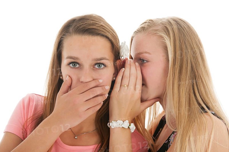 Teen girls are whispering gossip to each other