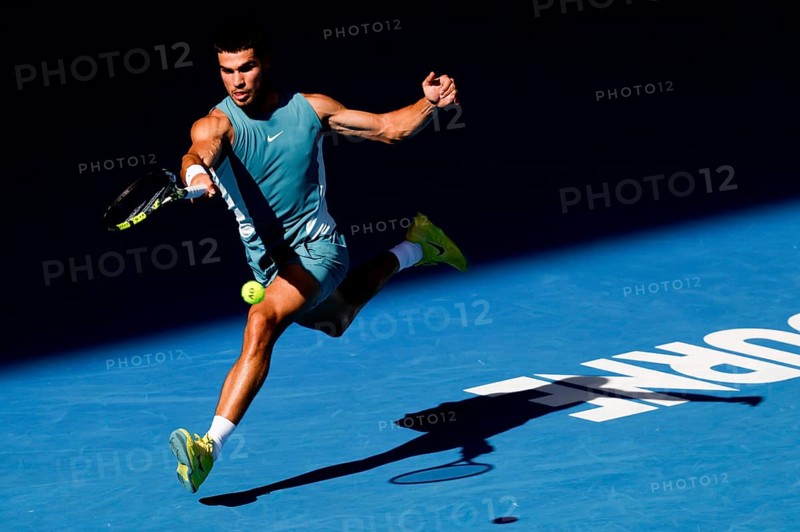 MELBOURNE, AUSTRALIA - JANUARY 19: Carlos Alcaraz of Spain hits a forehand to Jack Draper of Great Britain on day eight of the 2025 Australian Open at Melbourne Park on January 19, 2025 in Melbourne, Australia, Oceania