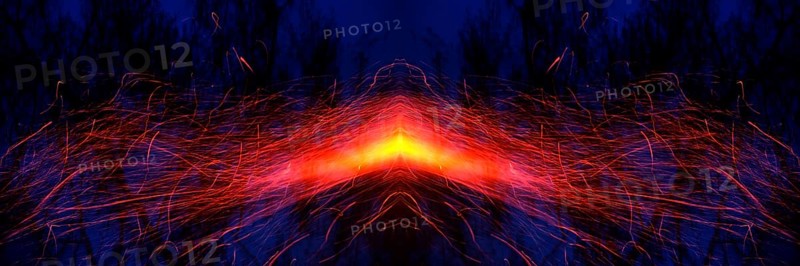 From a glowing hot centre in shades of yellow and orange, bright red trajectories of sparks move symmetrically to the left and right sides of the picture. Landscape format. Out of a glowing hot centre in yellow and orange tones, flight tracks of sparks move symmetrically to the left and to the right side of the image. Horizontal format